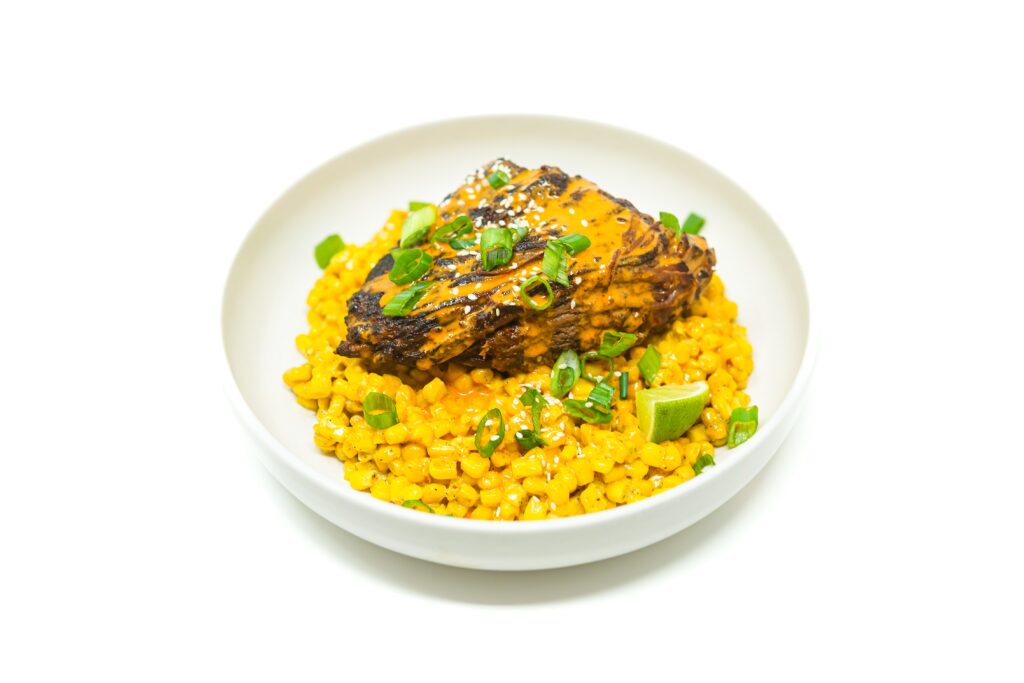 A plate of Korean-Mexican fusion braised beef brisket, slow-cooked to tender perfection with gochujang, chipotle, and citrus, served with fresh garnishes.