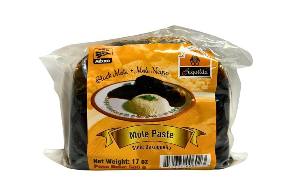 Package of Juquilita Black Mole Paste (Mole Negro), a traditional Oaxacan mole made in Mexico, featuring a plate of mole and rice on the label.