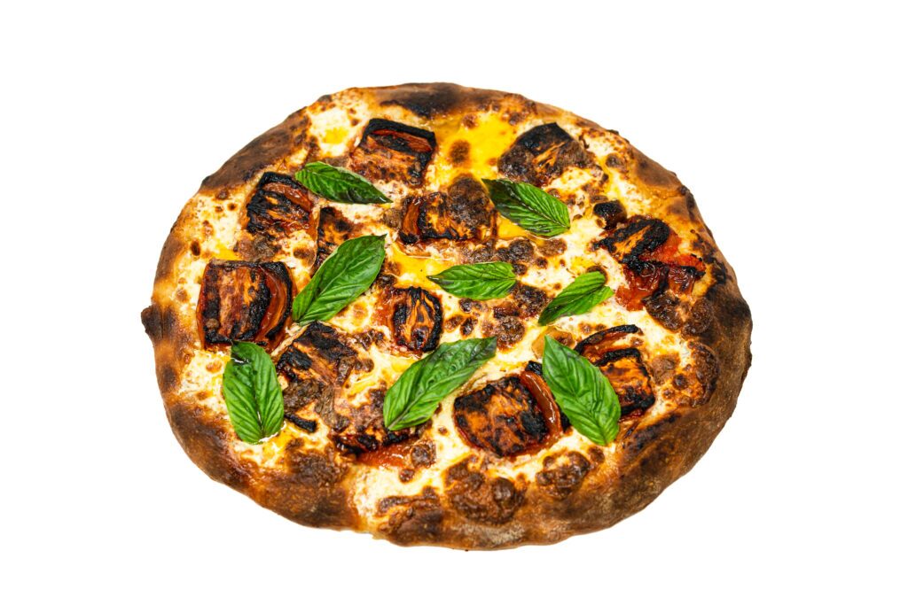 A rustic homemade pizza topped with Roma tomato confit, fresh mozzarella, and basil leaves on a wooden board, showing a golden, crisp crust glistening with confit oil.