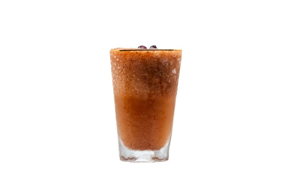 Frozen Thomcord Grape Mule cocktail with frozen grape garnish in a tall glass