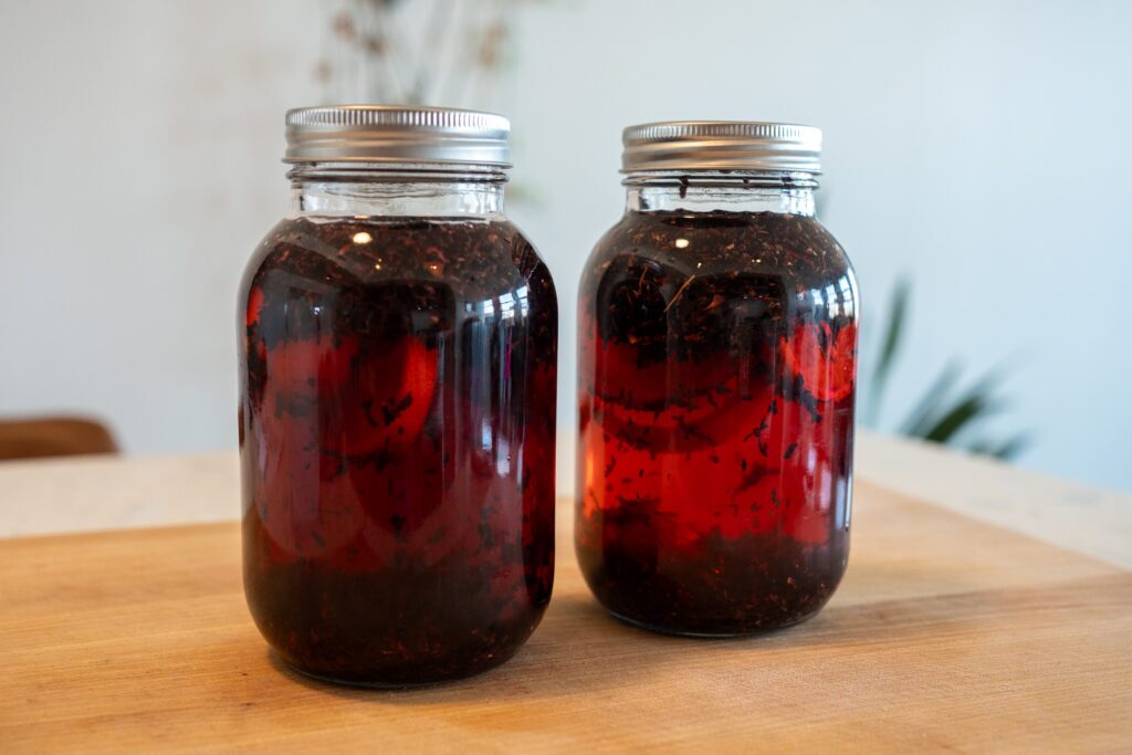 Cold brew hibiscus tea steeping in mason jars showing deep ruby red color after 24 hours